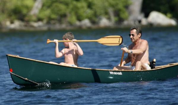 France's President Nicolas Sarkozy paddles a canoe with his son Louis on Lake Winnipesaukee while on vacation in Wolfeboro, New Hampshire August 4, 2007.  REUTERS / Neal Hamberg (UNITED STATES)