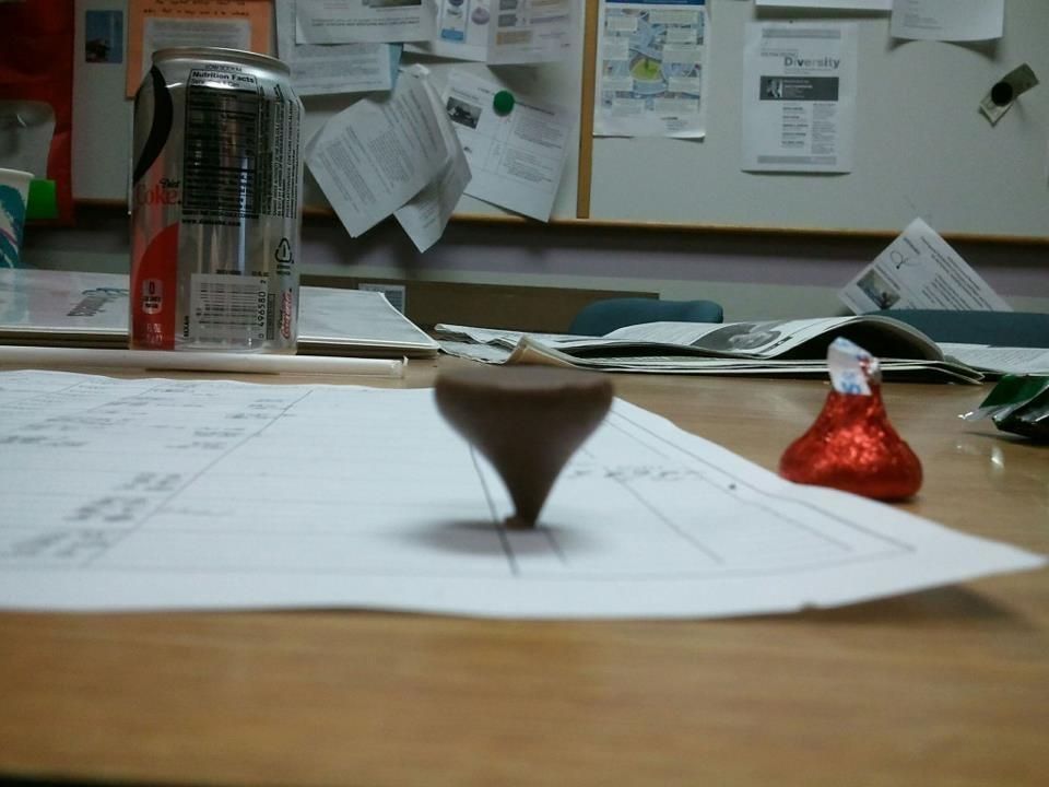Chocolate Hershey's kiss balancing on its tip. 