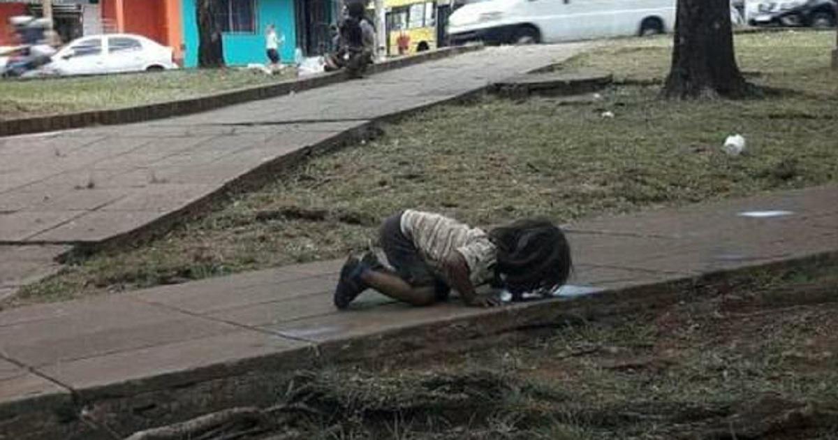 Φτωχό κορίτσι πέφτει στα γόνατα και πίνει βρώμικο νερό από λακκούβα κατά τη διάρκεια μεγάλου καύσωνα σε φτωχογειτονιά της Αργεντινής
