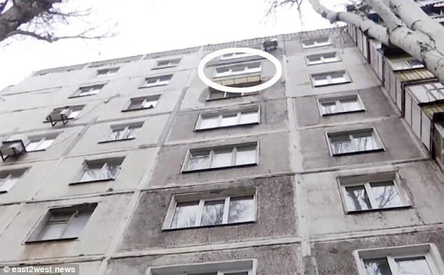 Shock: The man either jumped or fell from this window in Zaporizhia, southeastern Ukraine.