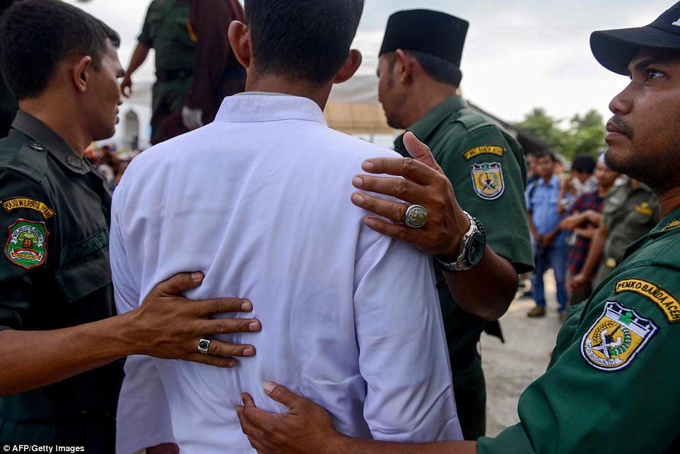 Τρεις αστυνομικοί με επένδυση σε κοσμήματα από στερλίνα οδηγούν τον Σίμμπιλωνα να είναι αγκυλωμένος. Είναι μόνο ο τρίτος μη μουσουλμάνος που υποφέρει από δημόσιο χτύπημα, δεδομένου ότι το Aceh, στο νησί Σουμάτρα, άρχισε να εφαρμόζει τον ισλαμικό νόμο αφού του χορηγήθηκε ιδιαίτερη αυτονομία το 2001 - μια προσπάθεια της κεντρικής κυβέρνησης για την εξουδετέρωση μιας μακρόχρονης αυτονομιστικής εξέγερσης