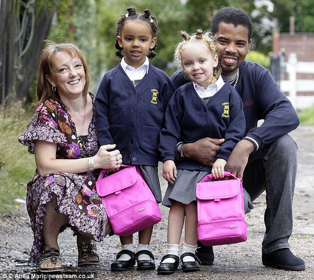 The girls, posing above with parents in matching hair and outfits heading off to school, are often mistaken for best friends rather than twins 