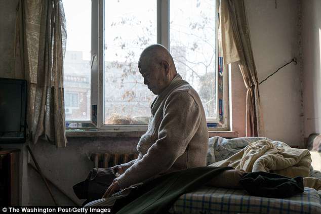 Han Zicheng, 85, sits in bed to take off his pants, revealing the wool pants inside that he usually wears at home, fearing that he will be found just as a pile of bones