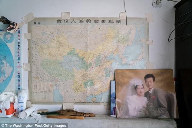 A wedding photo of the younger son of Han Zicheng is displayed in Han's living room/bedroom. The son's family has migrated to Canada in 2003