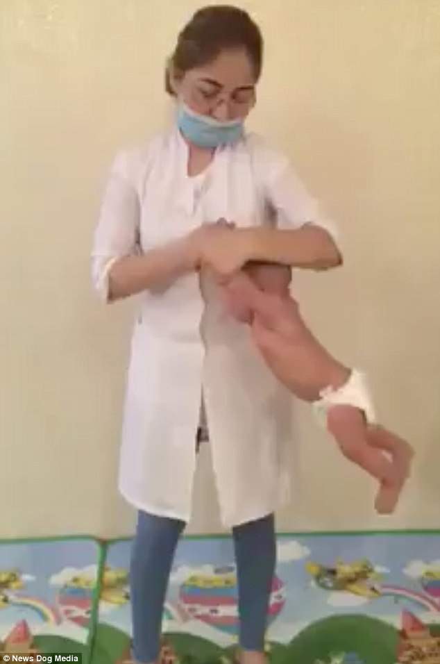 The baby is flung from side to side during the shocking treatment session in Kazakhstan