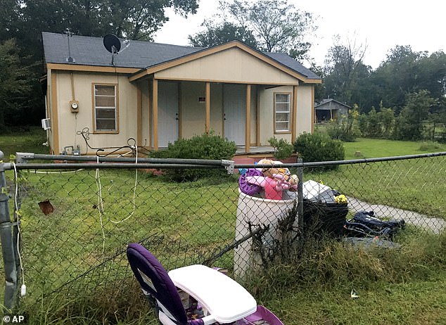 Royalty's toys, a discarded high chair and police evidence tape are part of the trash outside a home on Tuesday where she was found dead inside an oven on Monday evening