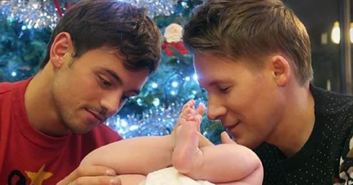 Γκέι ζευγάρι αντρών φωτογραφίζονται με τον 6 μηνών γιο τους μπροστά από το Χριστουγεννιάτικο δέντρο