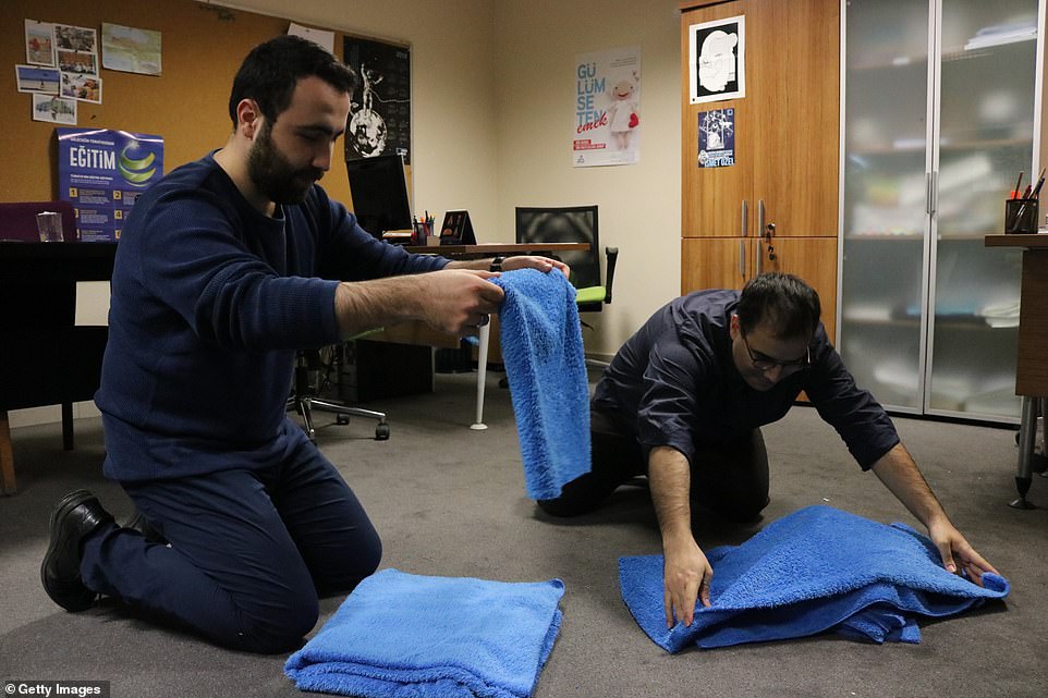 Preparations: Yurtseven, right, and a friend fold up the blue blankets as they prepare for another night of helping animals. HeÂ saw street dogs living in his neighbourhood and decided to helpÂ 
