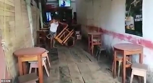 Attack: A woman is seen hitting her husband with a chair after allegedly finding him drinking with a group of other women in a local bar inÂ Iquitos, northern Peru